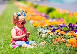 enfant dans l'herbe jouant avec les fleurs