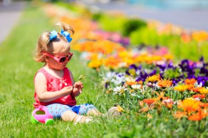 enfant dans l'herbe jouant avec les fleurs