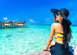 Femme au bord de l'eau avec un chapeau