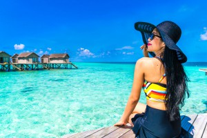 Femme au bord de l'eau avec un chapeau