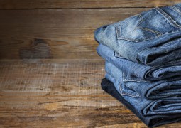 5 jeans pliés sur une table en bois