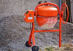 Voici une image d'une bétonnière de couleur orange d=sur un chantier