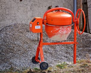 Voici une image d'une bétonnière de couleur orange d=sur un chantier